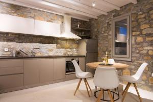 a kitchen with a wooden table and white chairs at Dreamy Cycladic Luxury Summer House 2 in Serifos Chora