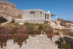a stone house on top of a hill with flowers at Dreamy Cycladic Luxury Summer House 2 in Serifos Chora +7 photos
