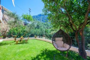 カラマタにあるAlmyros Aktis private garden apartmentの木の横の庭に座る籐椅子