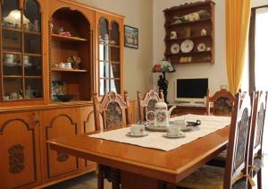 uma sala de jantar com uma mesa de madeira e cadeiras em casa vacanze Nonna Nunzia em Bosa
