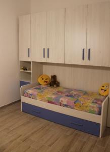 1 dormitorio con 1 cama con armarios blancos en casa vacanze Nonna Nunzia, en Bosa