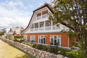 a large orange house with a white roof at Strandhaus Claassen 06 in Ahrenshoop