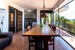a kitchen and dining room with a wooden table and chairs at Grifeu 07 - Apartamento con vistas al mar in Girona