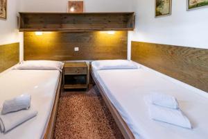 two twin beds in a room with a wooden wall at Grifeu 07 - Apartamento con vistas al mar in Girona