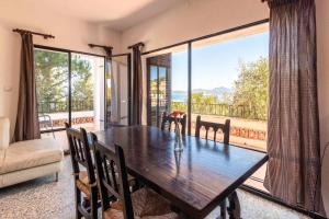 une salle à manger avec une table en bois et un balcon dans l'établissement Grifeu 6 Apartamento luminoso con terraza y vistas, à Gérone
