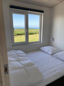 a white bedroom with two beds and a window at Aa Strand Camping in Ebberup