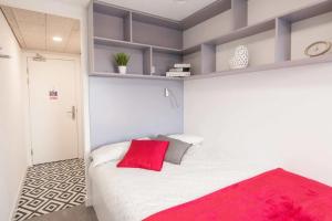 a bedroom with a large white bed with red pillows at Paradise Village Coventry in Coventry +9 photos