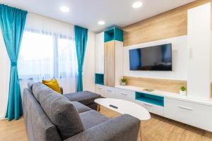 a living room with a couch and a tv at Arena Residence in Cluj-Napoca