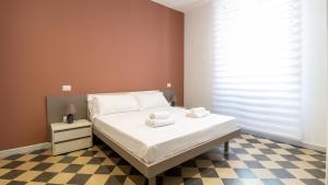 sypialnia z łóżkiem i szachownicą w obiekcie Welcomely - Xenia Boutique w mieście Oristano