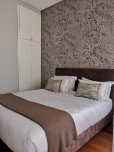 um quarto com uma cama grande e uma parede em Mouzinho 129 - Carvalho no Porto