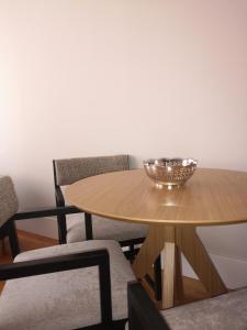uma mesa de madeira com cadeiras e uma tigela sobre ela em Mouzinho 129 - Carvalho no Porto