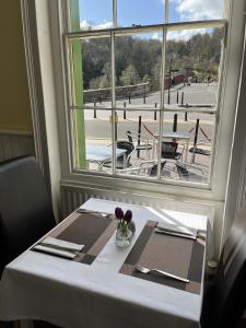 a table with a white table cloth and a window at The Tontine Hotel & Bar in Ironbridge