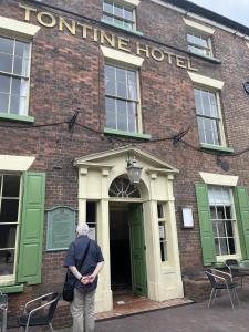 a woman standing in front of a hotel at The Tontine Hotel & Bar in Ironbridge
