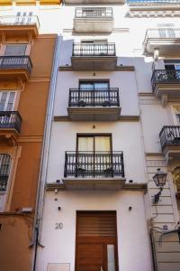 een hoog wit gebouw met balkons en een deur bij VLC Host - Mercat Central in Valencia