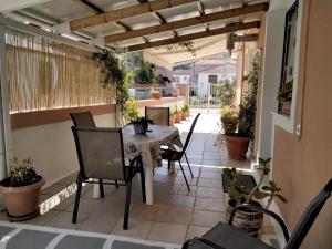 un patio esterno con tavolo, sedie e piante di Ralloy Hoyse a Sami