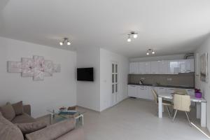 uma sala de estar e cozinha com um sofá e uma mesa em Apartments Fortinia Dubrovnik- FREE PARKING em Dubrovnik