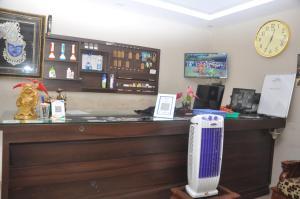 a bar with a fan and a clock on the wall at HOTEL TEMPLE CITY in Papanāsam