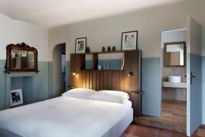a bedroom with a large white bed and a mirror at Cà del Re in Verduno