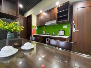 a kitchen with a dining table and a green wall at New Tourane Hotel in Danang