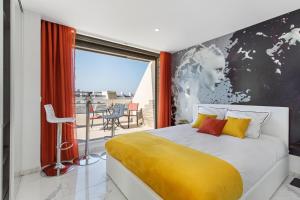 een slaapkamer met een groot bed en een gele deken bij Village Naturiste - Emotion X Heliopolis sea view in Cap d'Agde