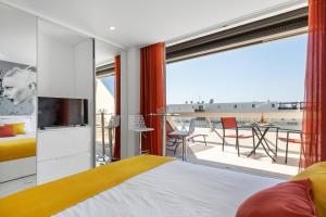 een slaapkamer met een bed en een balkon bij Village Naturiste - Emotion X Heliopolis sea view in Cap d'Agde