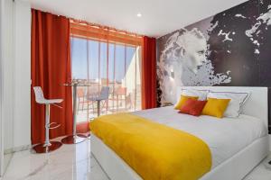 een slaapkamer met een groot bed en een gele deken bij Village Naturiste - Emotion X Heliopolis sea view in Cap d'Agde