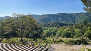 a view of a valley with a picnic table and mountains at Le Cabanon in Collobrières