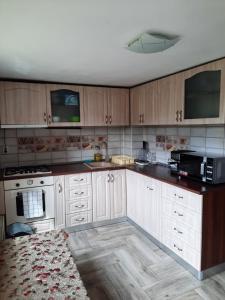 a kitchen with white cabinets and a black counter top at Casa Flavia in Poiana Mărului