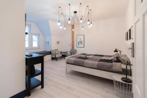a bedroom with a bed and a desk and a chandelier at Sopot, the very heart! in Sopot