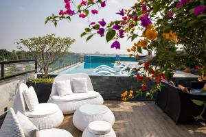 a balcony with white chairs and a view of a pool at Lalita Boutique Hotel & Spa Ninh Binh in Ninh Binh