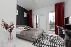 a bedroom with a bed with a table and a window at Business Center Apartments Warsaw Wola by Renters in Warsaw