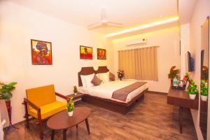 a hotel room with a bed and a chair at Octave Parkland Suites in Nagpur