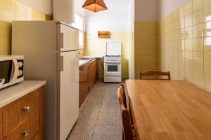 cocina con mesa de madera y nevera en Sant Genís 19 ático con terraza y vistas en Girona