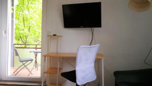 Elle comprend un bureau avec une chaise et une télévision murale. dans l'établissement Apartment am Südpark, à Merseburg