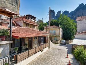 una calle en una ciudad con casas y montañas en The Stone House, en Kalambaka