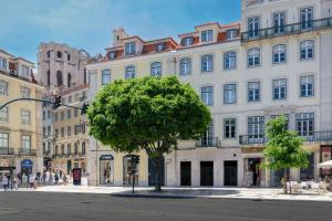 リスボンにあるNicola Rossio Hotelの白い大きな建物の前の木