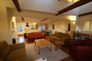 a living room with couches and a table at Spixworth Hall Cottages in Spixworth