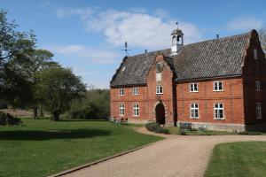 a large red brick building with a clock tower at Spixworth Hall Cottages in Spixworth