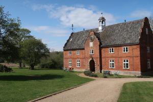 ein großes rotes Backsteingebäude mit einem Uhrturm in der Unterkunft Spixworth Hall Cottages in Spixworth