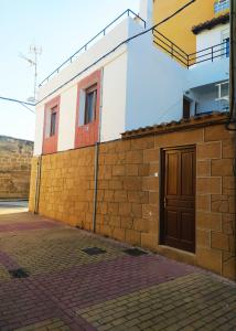 a brick wall next to a building with a door at El Rincón de Pilar in Casalarreina