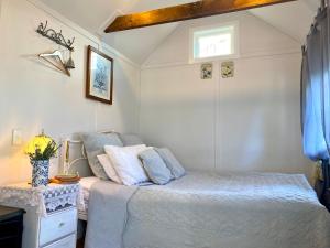 a small bedroom with a bed and a window at Thistle and Pine Cottage Farmstay in Tauranga