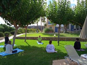 un grupo de personas sentadas en la hierba bajo un árbol en Sweety Club Solimar Emerald ALL INCLUSIVE, en Adelianos Kampos