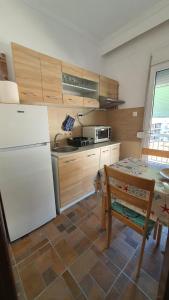 a kitchen with a white refrigerator and a table at Nea Kalikratia sea view in Nea Kallikrateia