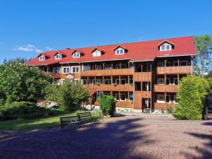 a large building with a bench in front of it at Gierałtówka Apartamenty in Nowy Gierałtów