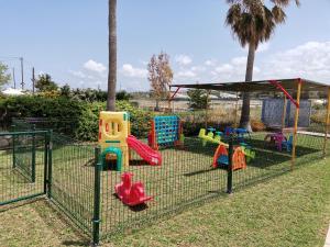 un parque infantil con equipo de juego colorido en una jaula en Sweety Club Solimar Emerald ALL INCLUSIVE, en Adelianos Kampos