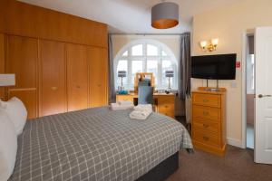 a bedroom with a bed and a flat screen tv at The Crown Hotel in Weymouth