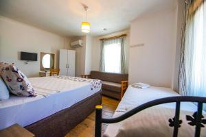 ein kleines Schlafzimmer mit zwei Betten und einer Couch in der Unterkunft Bozcaada Vitis Hotel in Bozcaada