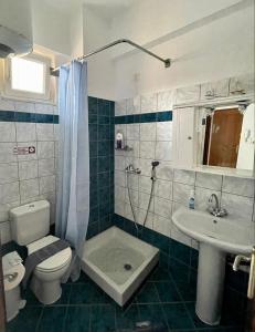 y baño con aseo, lavabo y ducha. en ALEKA KOTSI ROOMS, en Igoumenitsa