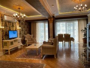 a living room with a television and a dining room at Sea view luxury in Baku