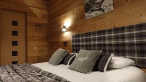 Un dormitorio con dos camas en una habitación con paredes de madera. en Hôtel Viallet, en Arêches